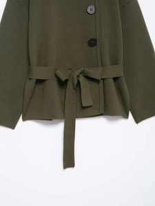 Close-up of olive knit cardigan with large black buttons and matching tied waist belt