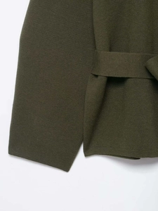 Detail view of olive green knit cardigan featuring high-density texture and matching waist belt