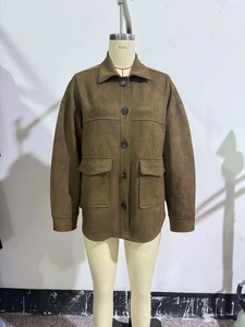 Detail of dark brown faux suede jacket with classic collar and symmetrical flap pockets