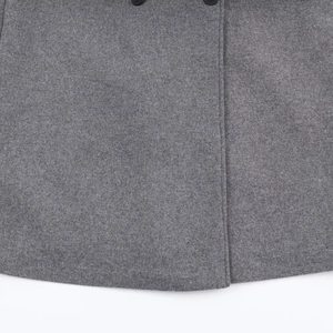 Détail du tissu en laine gris foncé avec bouton noir et finitions de couture précises