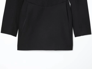 Detailed view of structured waist pleats and fabric texture on black blazer dress