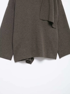Detail of knitted short coat with elegant layered scarf collar and drop shoulder design