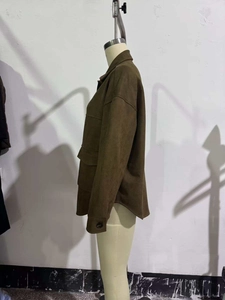Close-up of brown faux suede shirt jacket featuring large flap pockets and matte texture
