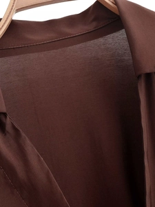 Détail du col d'une chemise marron chocolat et texture d'un tissu de haute qualité