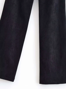 Detailed macro view of black wide-leg trousers featuring high-quality faux suede fabric texture
