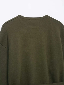 Detail view of military green knit sweater showing neck and shoulder texture