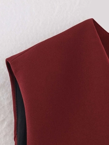 Close-up of wine red vest showing fine stitching, woven texture and black lining