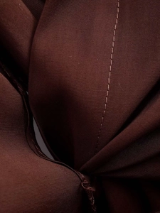 Détail du tissu sergé marron foncé avec coutures simples précises sur une chemise