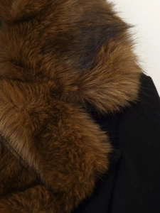 Close-up of the dense dark brown faux fur collar on the black wool coat for winter