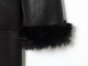 Détail de la manche en suédine noire avec revers en fausse fourrure et couture nette