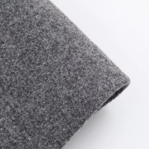Texture macro détaillée du tissu gris en laine montrant la qualité épaisse des fibres