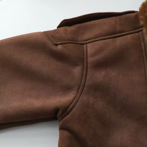 Close-up of topstitching and plush fur collar detail on dark brown suede jacket