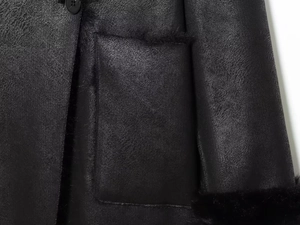 Détail de la doublure en fausse fourrure noire et texture cuir d'un manteau d'hiver