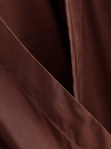 Détail des coutures précises et du tissu mat sur cette chemise marron chocolat