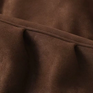 Detailed macro view of dark brown suede fabric texture and reinforced double stitching