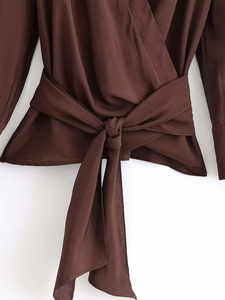 Détail d'un chemisier croisé marron chocolat avec ceinture réglable et col en V