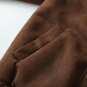 Close-up of brown faux suede motorcycle jacket showing pocket detail and fine stitching