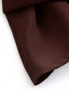 Vue macro de la texture du tissu tissé marron foncé et des coutures de la chemise