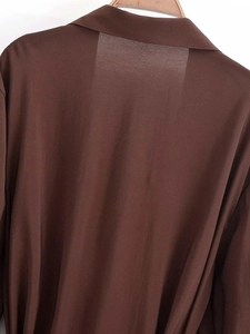Détail d'une chemise marron foncé à manches longues avec col classique et tissu lisse