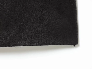 Détail macro du tissu en daim noir haute densité avec texture mate et bords nets