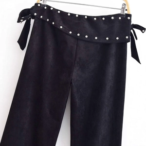 Elegant high-waisted black suede wide-leg pants with silver stud trim and tie-waist detail