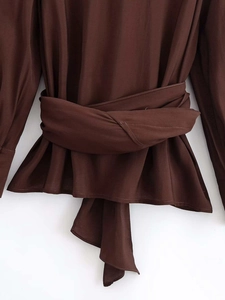 Détail d'une chemise marron chocolat à manches longues avec taille croisée et volant