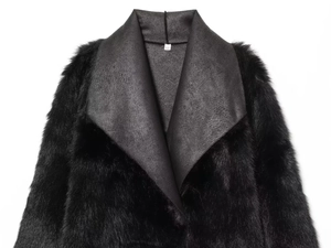 Gros plan détaillé de la texture en fausse fourrure et du revers en cuir du manteau noir