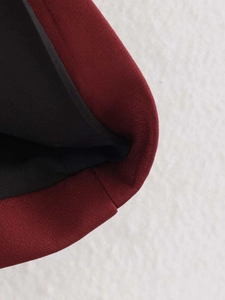 Detail view of burgundy slim-fit vest showing woven texture and black smooth lining