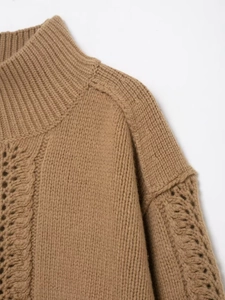Detailed view of brown cable knit pattern and ribbed high neck sweater texture