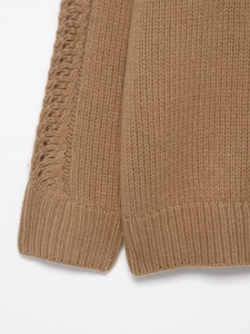 Detailed cable knit pattern and ribbed cuff on a camel winter turtleneck sweater