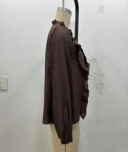Detail of dark brown long sleeve shirt with layered ruffles and textured fabric
