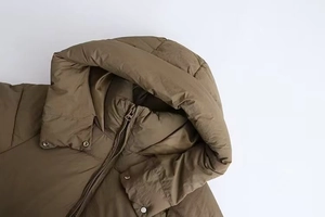 Detailed close-up of the hooded collar and snap buttons on a khaki winter parka jacket