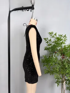 Détail d'une mini robe noire à paillettes moulante avec un décolleté licou sur un mannequin