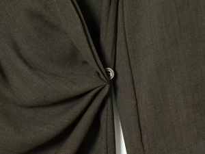 Detailansicht der olivgrünen Bluse mit plissierter Textur und passendem Harzknopf