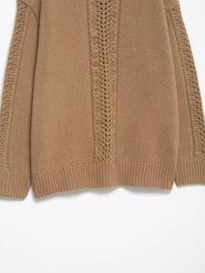 Detail of cable knit pattern and eyelet stitches on a camel winter sweater