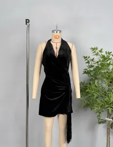 Detail of black velvet halter dress featuring waist ruching and side fringe trim