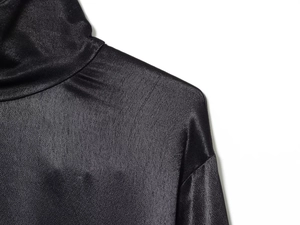 Detailed macro view of the glossy black satin texture and high-neck collar stitching