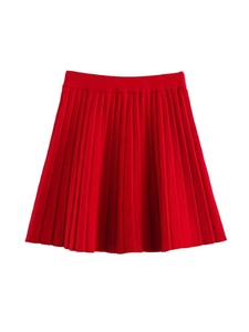 Détail de la mini-jupe plissée rouge vif avec une texture tricotée épaisse et taille haute