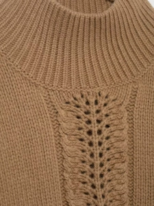 Close-up of cable knit pattern and ribbed neckline on camel winter sweater