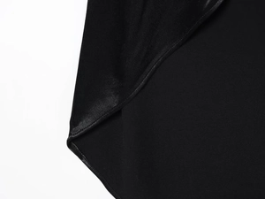Detail of the high-quality black satin fabric and fine stitching on the slim-fit dress