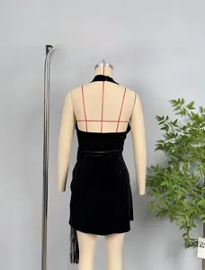 Detail of black velvet halter dress featuring side fringe trim and sleek bodycon silhouette