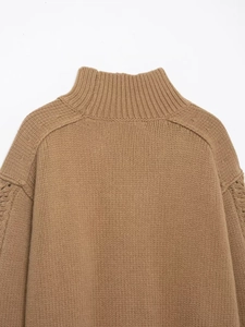 Detailed view of camel cable-knit sweater featuring a high neck and textured sleeve pattern