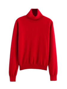 Gros plan détaillé d'un pull en tricot rouge à col roulé avec poignets et ourlet côtelés