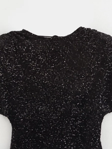 Gros plan de paillettes noires sur une robe ajustée avec une finition scintillante