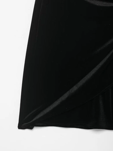 Detailed macro shot of the premium black velvet fabric texture and sheen on dress hem