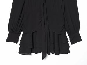 Detailansicht eines schwarzen Stufenkleides aus Chiffon mit eleganten Rüschen und Lagenlook