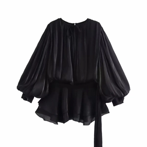 Elegant black pleated long sleeve blouse with puff sleeves and irregular hemline