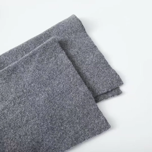Detail of medium grey knit cardigan fabric showing thick texture and wool finish