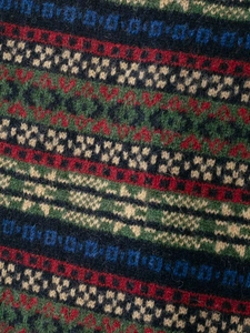 Detailed macro shot of vintage Fair Isle knit pattern in wool blend with vibrant colors