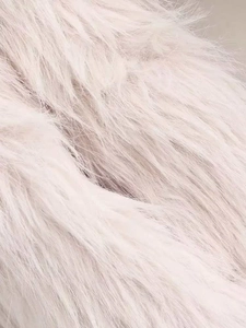 Close-up of soft beige faux fur texture on a vintage oversized winter coat for women